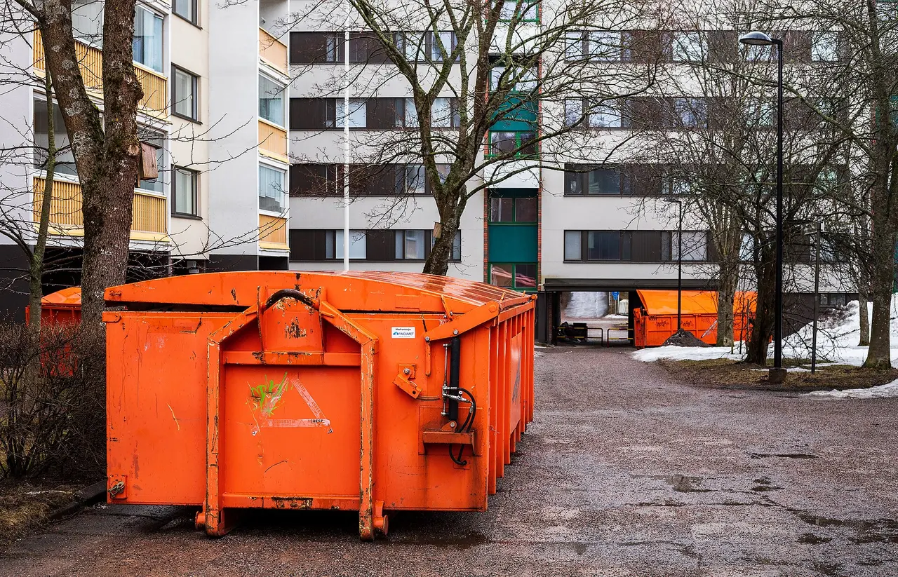 Narancssárga, kihelyezett konténerek egy lakóépület mellett